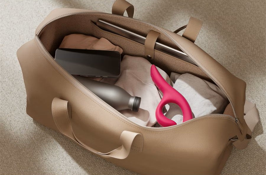 Nova Rabbit Vibrator packed inside an open travel bag next to everyday items like clothing and a water bottle