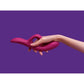 Hand holding the Nova Rabbit Vibrator against a purple background, showcasing ergonomic design and soft silicone texture