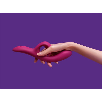 Hand holding the Nova Rabbit Vibrator against a purple background, showcasing ergonomic design and soft silicone texture