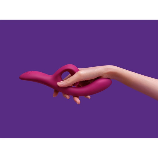 Hand holding the Nova Rabbit Vibrator against a purple background, showcasing ergonomic design and soft silicone texture